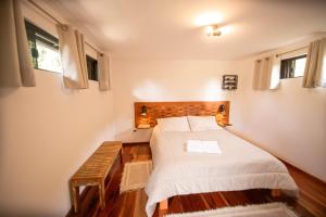 a bedroom with a bed and a bench in it at Suíte Jasmim branco in Campos do Jordão