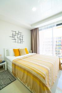 una camera da letto bianca con un letto giallo e bianco di Pool View Tropic Studio a Ban Mai Salae Altre 34 foto