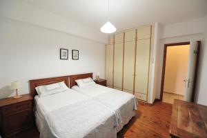 a bedroom with a large bed with white sheets at Villa Pefka in Skiathos