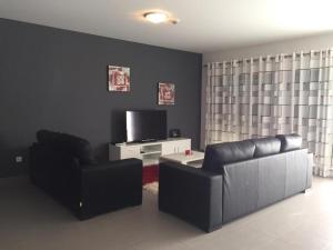 a living room with a couch and a tv at Paraíso à Beira-Mar - Sol&Praia in Portimão