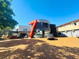 Un edificio con un coche aparcado en un estacionamiento. en Hotel 7, en Três Lagoas