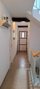 a hallway with a door and a tile floor at Casa TEO in Entrena