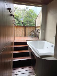 a bathroom with a bath tub and a balcony at Santuário da Chapad a dos Veadeiros in Alto Paraíso de Goiás