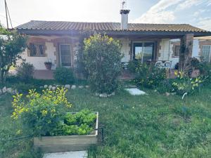una pequeña casa con un jardín frente a ella en Masia en el Delta del Ebro, en L'Aldea