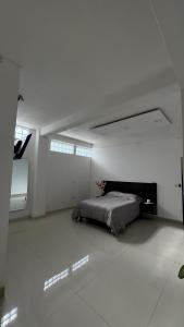 Santa Ana ChiautempanにあるHabitación en departamento de lujoの白い部屋にあるベッドのある寝室