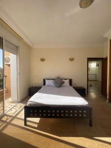 Un dormitorio con una cama y una ventana grande. en Villa for rent in Nouaceur, en Nouaseur