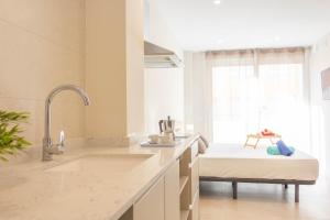 a white kitchen with a sink and a window at Aparthotel al centro de Peñiscola - Mar de Cristal in Peñíscola