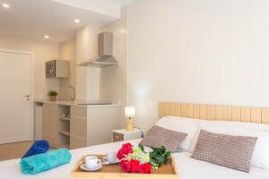 a room with a bed with a tray of flowers on it at Aparthotel al centro de Peñiscola - Mar de Cristal in Peñíscola