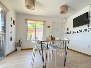 a dining room with a table and white chairs at Casas de Cafayate in Cafayate