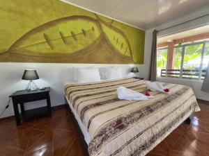a bedroom with a bed with a large painting on the wall at Hotel Dorado Hot Springs in Fortuna
