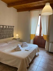 a bedroom with a bed with towels on it at La Vecchia Torre in Bosa