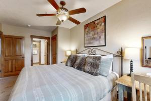 Un dormitorio con una cama con ventilador de techo. en Mountain Thunder 5202, en Breckenridge 20 fotos más