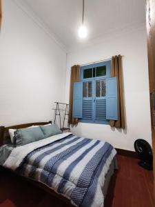 Duas BarrasにあるFazenda Santa Cruzのベッドルーム1室(青い窓、ベッド1台付)