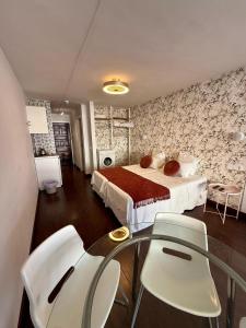 een slaapkamer met een bed, een tafel en stoelen bij Central Charco in Puerto de la Cruz