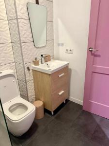 een badkamer met een toilet, een wastafel en een spiegel bij Central Charco in Puerto de la Cruz +16 foto's