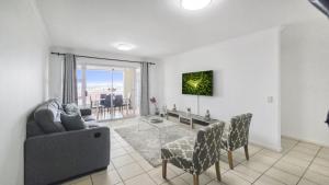 a living room with a couch and a table and chairs at Homely 3 Bedroom apartment in Villa Italia Century City in Cape Town