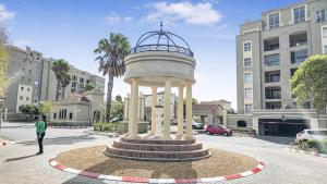 a man standing in front of a tower in a street at Homely 3 Bedroom apartment in Villa Italia Century City in Cape Town