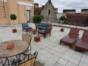 un patio con mesas y sillas, una mesa y bancos en Aglaya Hotel & Courtyard, en San Petersburgo