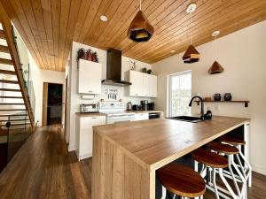 a kitchen with a wooden ceiling and a wooden counter top at Chalet aux ℳille et une vues in Petite-Rivière-Saint-François