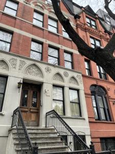 a brick building with stairs leading to a door at NYC Townhouse Apartment in New York
