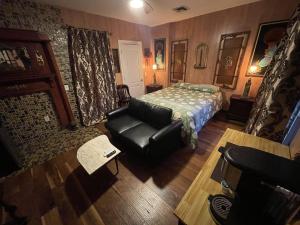 a bedroom with a bed and a couch and a chair at NYC Townhouse Apartment in New York