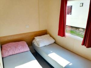 a small room with two beds and a window at kraina jezior in Skorochow
