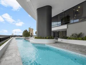 a swimming pool in front of a building at Sky Living & River Views in Queens Wharf Residences in Brisbane