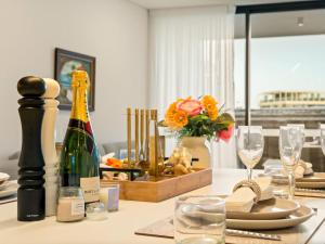 a table with a bottle of wine and glasses at 2BR West End Apt with Parking Walk to Convention Ctr in Brisbane