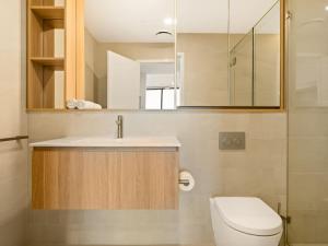 a bathroom with a sink and a toilet and a mirror at 2BR West End Apt with Parking Walk to Convention Ctr in Brisbane