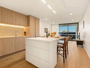 a kitchen with a white island and a dining room at 2BR West End Apt with Parking Walk to Convention Ctr in Brisbane +9 photos