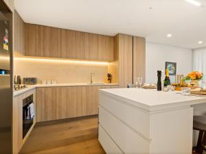 a kitchen with a white counter and wooden cabinets at 2BR West End Apt with Parking Walk to Convention Ctr in Brisbane