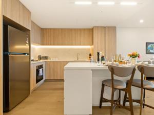 a kitchen with a refrigerator and a table with chairs at 2BR West End Apt with Parking Walk to Convention Ctr in Brisbane