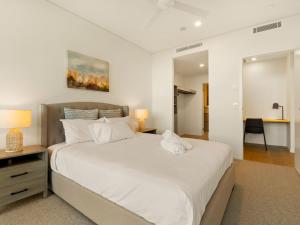 a bedroom with a large white bed and a desk at 2BR West End Apt with Parking Walk to Convention Ctr in Brisbane