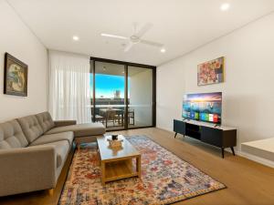 a living room with a couch and a tv at 2BR West End Apt with Parking Walk to Convention Ctr in Brisbane