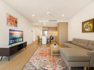 a living room with a couch and a tv at 2BR West End Apt with Parking Walk to Convention Ctr in Brisbane