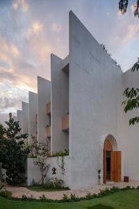 トゥルムにあるHotel Bacab Tulumの木製のドアが付いた白い建物のファサード