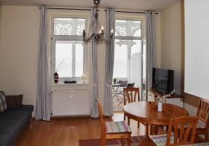 a living room with a couch and a table and chairs at Fürstenhof Sassnitz in Sassnitz