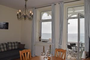 a living room with a table and a window at Fürstenhof Sassnitz in Sassnitz
