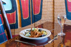 a plate of food on a table with a glass of wine at Glacier Bay Lodge in Gustavus +17 photos