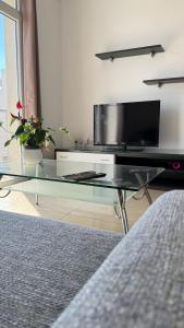 a living room with a glass coffee table with a tv at FP Spinola Whole Apartment - FREE WI-FI in St Julian's