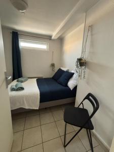 una piccola camera da letto con un letto e una sedia di Offre Novembre De l'ancre à la criée hyper centre Dunkerque a Dunkerque