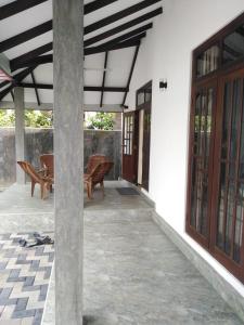 un porche de una casa con sillas y ventanas en Mystic home stay, en Nikawatawana