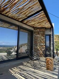 LichnaftiaÉar Suite的两把椅子放在带玻璃窗的甲板上