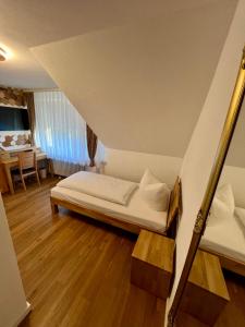 a small bedroom with a bed and a table at Hotel Restaurant Unikat in Zeltingen-Rachtig