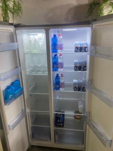 an open refrigerator filled with bottles of water and drinks at Rustic Retreat Rooms in Muggia