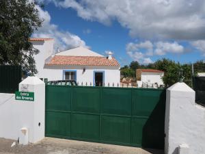 a green fence with a white house behind it at Ferienhaus Casa Limoeiro by fewo-plan ESTO101 an der Algarve in Azinheiro +20 photos