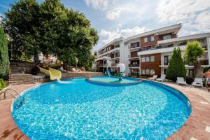 a large blue swimming pool in front of a building at Beachfront, 2 Bed with Sea Views in Elenite
