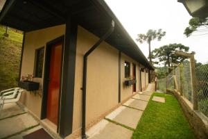 a building with a pathway next to a fence at Suíte jasmim rosa in Campos do Jordão +20 photos