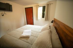 a bedroom with a bed with a pillow on it at Suíte jasmim rosa in Campos do Jordão