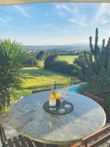 a table with two glasses and a bottle of wine at Torre Costa Brava Private pool in Garrigás